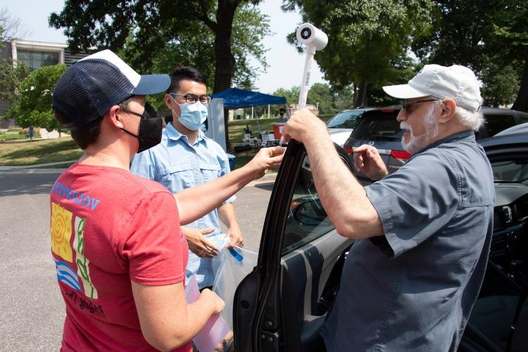 孙凤鹏帮助一名志愿者在汽车上安装传感器