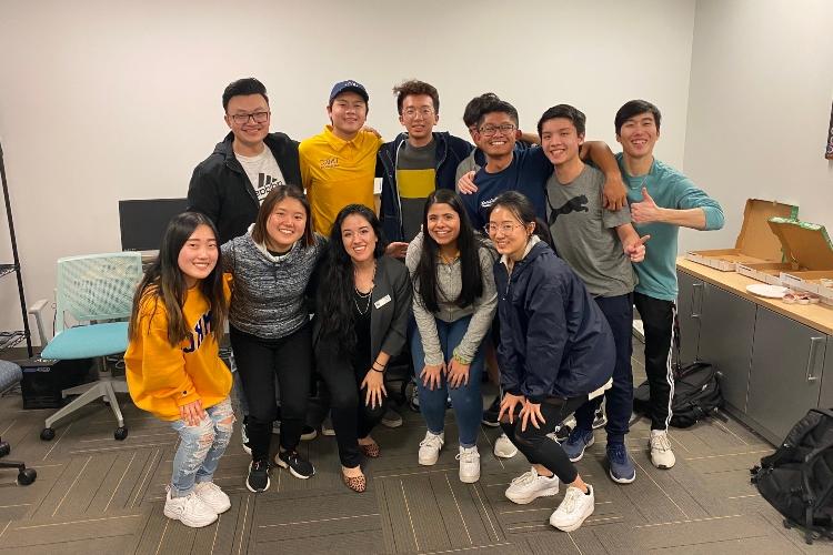 a large group of students stand in front of a blank white wall